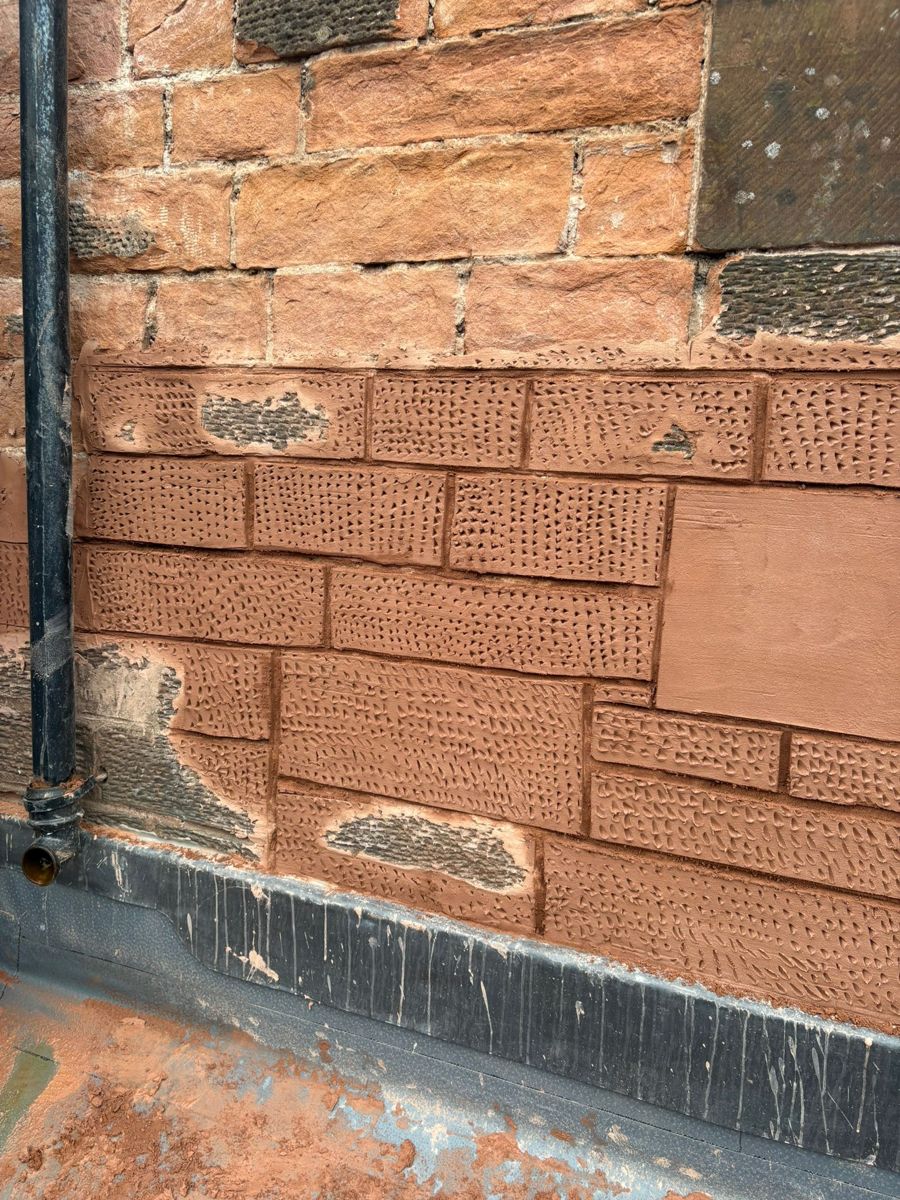 Red sandstone ashlar wall with leaded windows